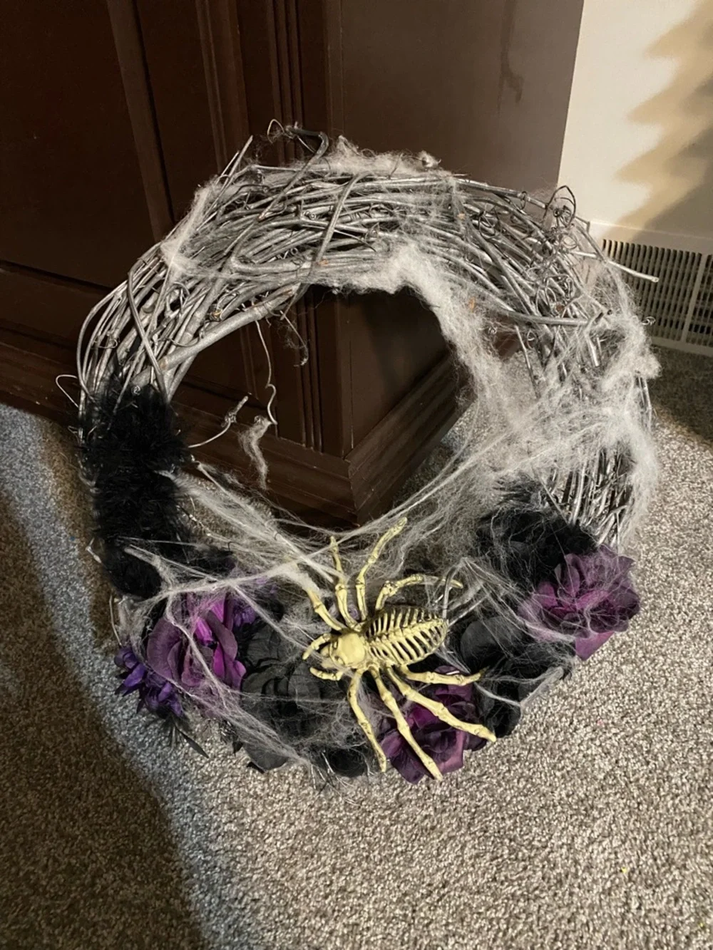 Halloween wreath with spider skeleton, flowers and cobwebs
